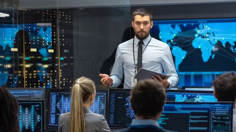 A professional leader giving a presentation in a command center with data screens, illustrating the path to becoming a Chief Technology Officer.
