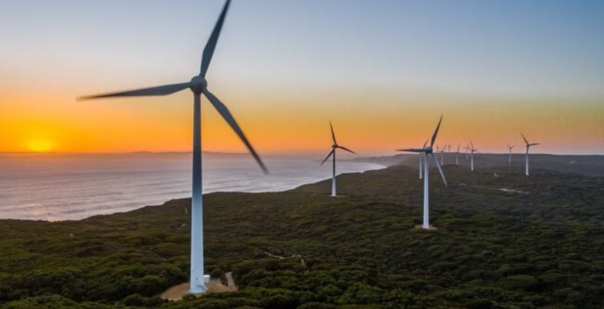 A scenic view of wind turbines at sunset, representing sustainable energy efforts.