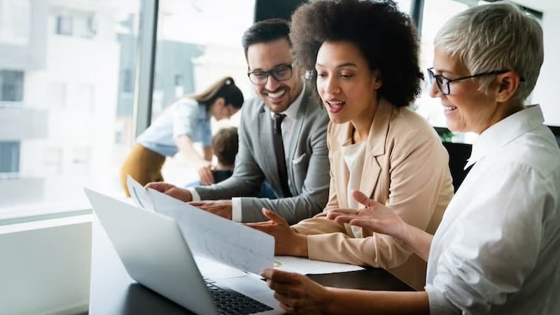 A group of research analysts engages in a collaborative discussion around a conference table.