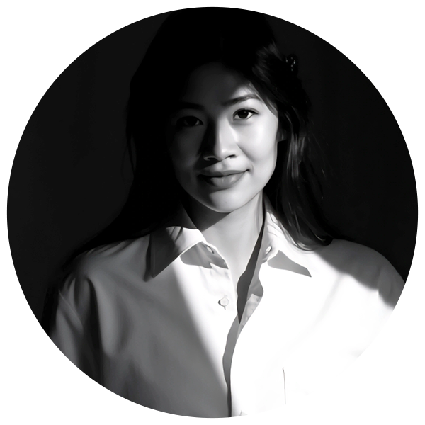 A woman in a white shirt poses for a photo, smiling and looking directly at the camera.