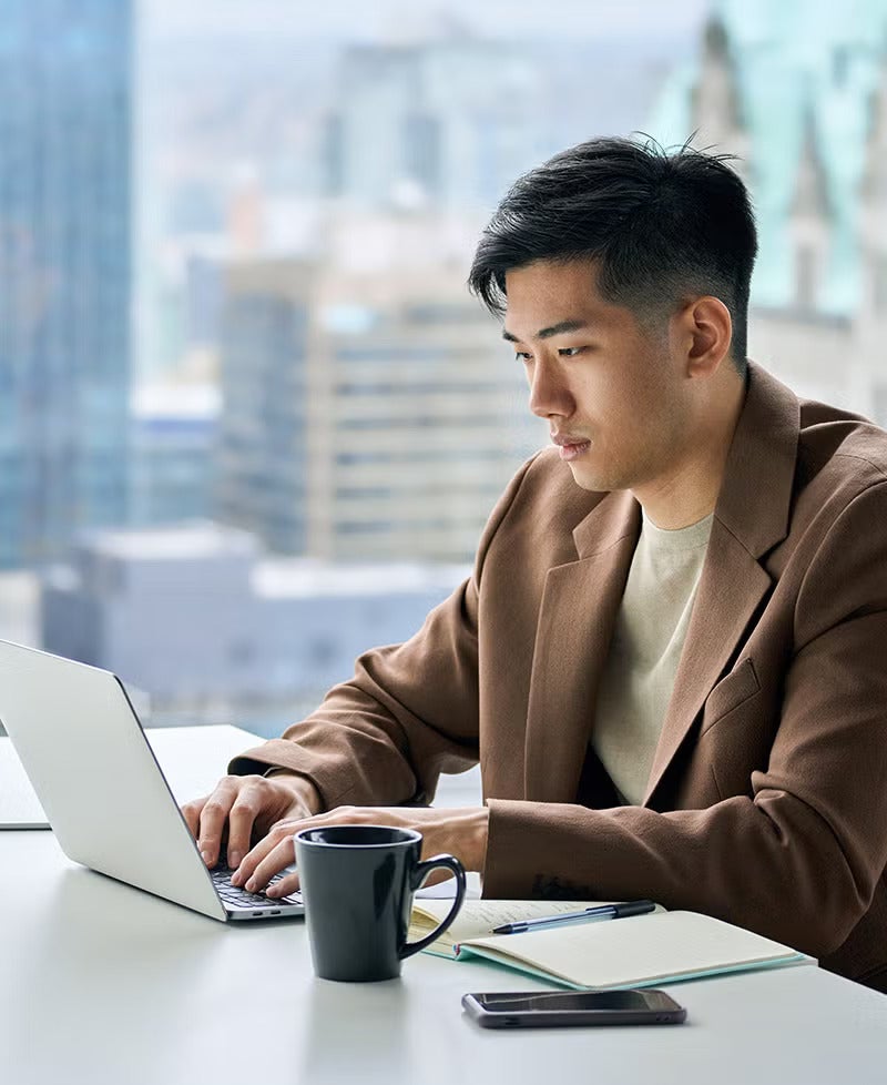 Man in a suit working on a laptop