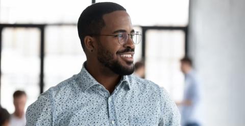 A smiling man in a casual shirt, representing a marketing manager career path.