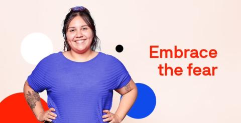 A woman smiling confidently, wearing a blue shirt, with the text 'Embrace the fear' beside her.