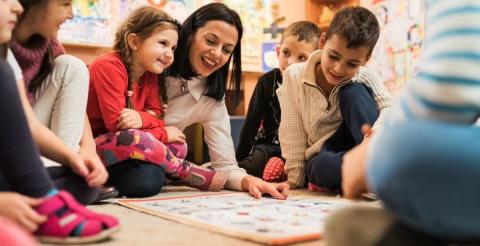 A teacher engaging with children during an interactive learning session in a classroom.