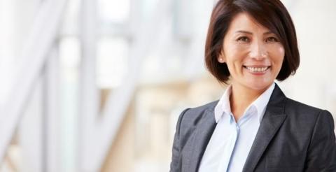 A smiling businesswoman in a professional setting, symbolizing career growth.