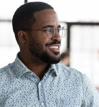 A smiling man in a casual shirt, representing a marketing manager career path.