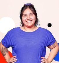 A student smiling confidently, wearing a blue shirt.