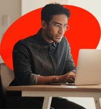 A focused student working on his laptop with the text "Commit to postgraduate study" overlaid.
