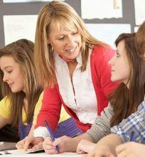 A teacher providing individual support to students working in a classroom environment.