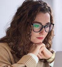 A focused woman wearing glasses, working on her laptop with text reading "Enhance study productivity" alongside productivity app icons.