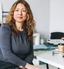 A women’s health professional seated at her desk, working in a clinical setting.