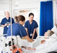 A nurse educator observing and guiding two nurses on patient care.