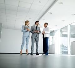 Three property valuers engaged in a discussion about a site valuation.