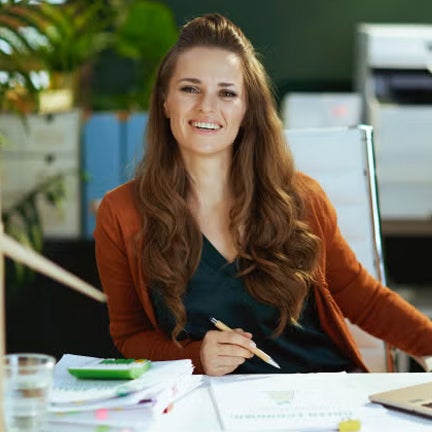 Woman smiling at camera in greenery filled office space