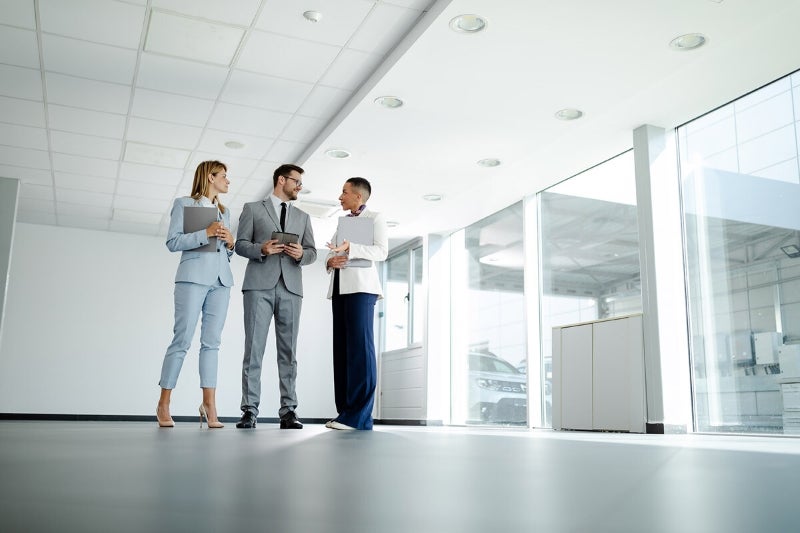 Three property valuers engaged in a discussion about a site valuation.