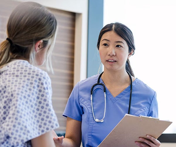 A caring nurse assisting a patient in a healthcare setting, demonstrating compassion and professionalism.