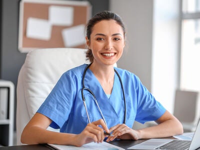 A smiling nurse sitting on a modern hospital office.
